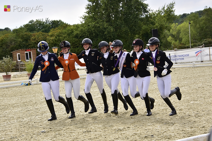 Sept des huit cavalières — la médaillée d’argent étant restée à poney — ont effectué leur tour d’honneur à pied, bras dessus, bras dessous. Une belle image, sympathique et complice ! – ph. Poney As
